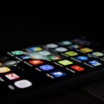 Smartphone showing apps against a black background representing how to create an app