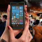 Pair of hands holding mobile phone displaying mobile apps