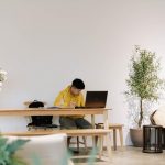 Remote worker sits at dining table in front of laptop