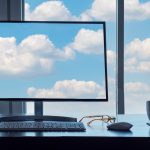 BSPOKE Softare - Clouds on a computer screen and thoruhg a window, representing hybrid cloud computing