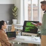 How to choose the right software house. Shows programmers around code.
