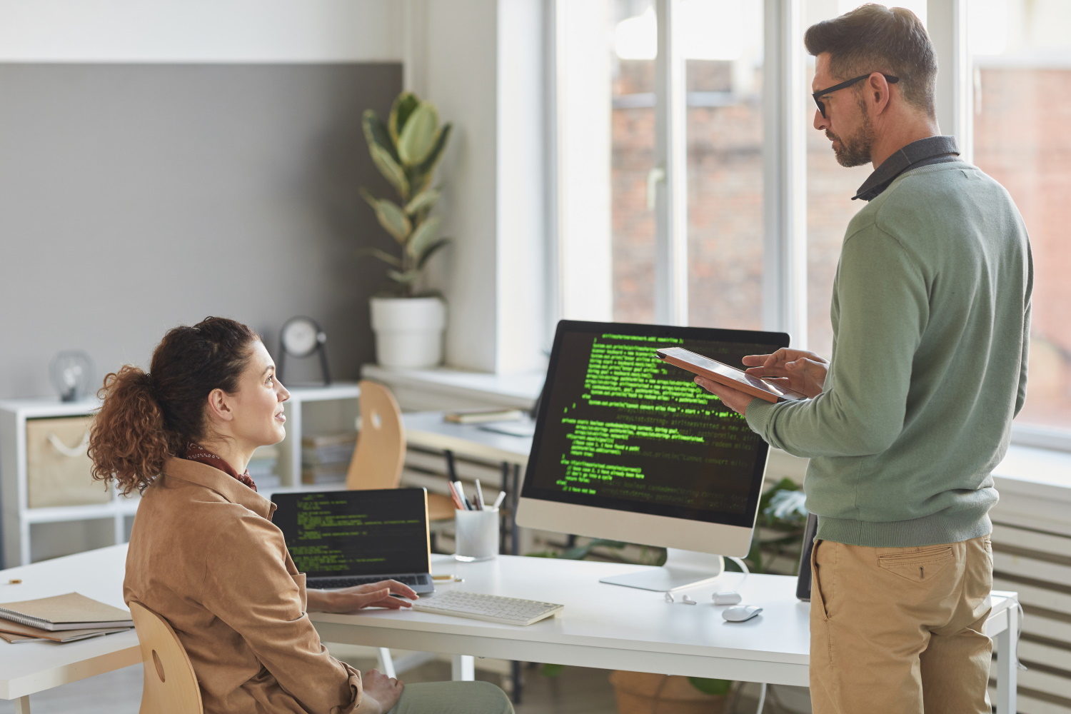 How to choose the right software house. Shows programmers around code.