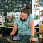 BSPOKE Software - Shows a coffee shop owner using bespoke software for small businesses